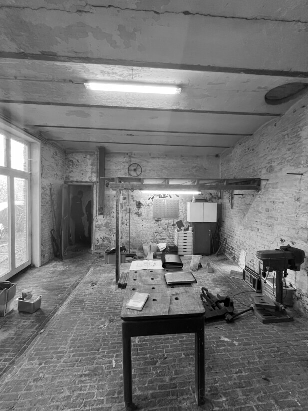Historisch interieur van koetshuis met zichtbare baksteenstructuur en draagconstructie