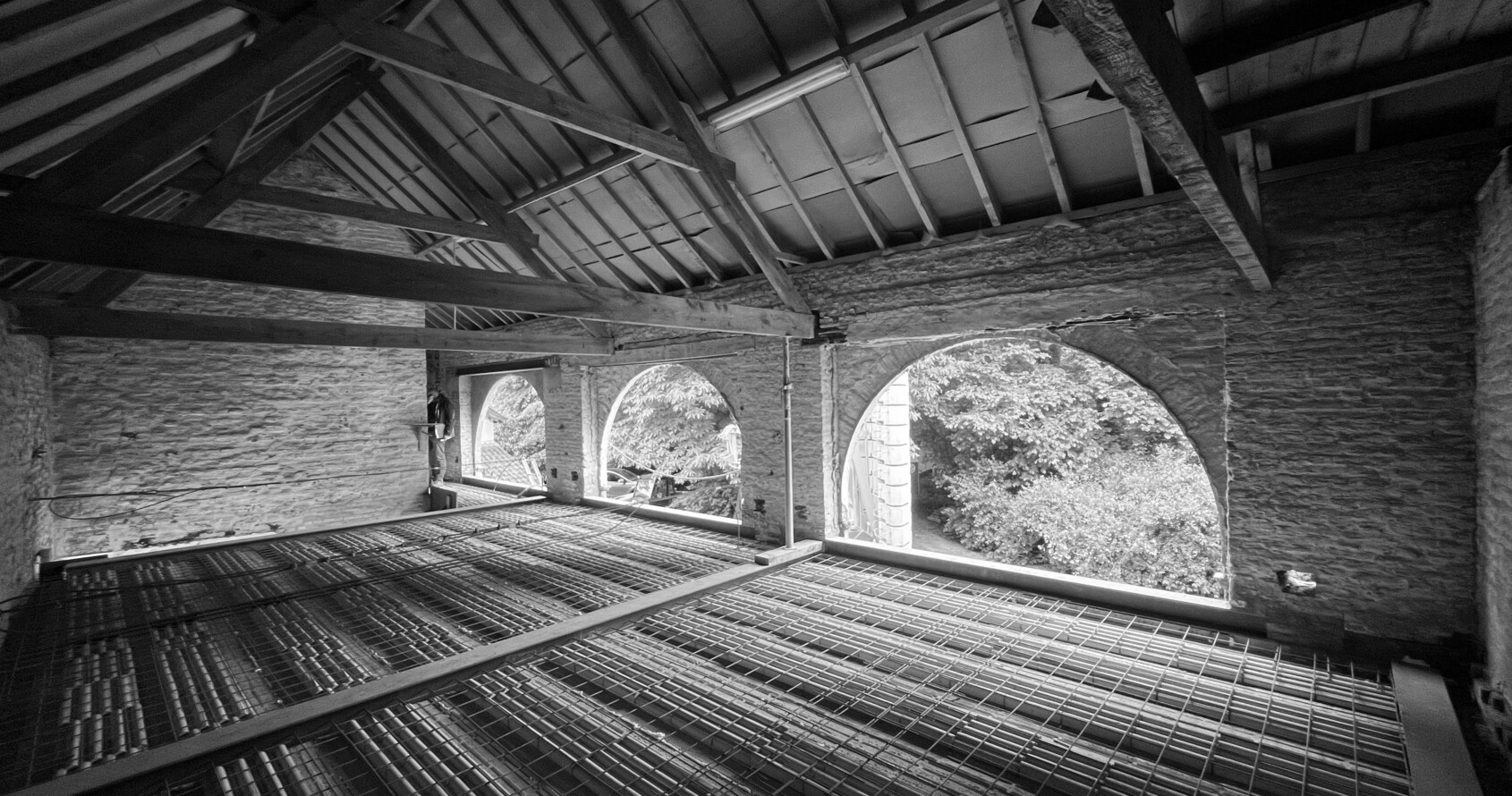 Historische dakstructuur gecombineerd met nieuwe vloerstructuur binnen erfgoedrenovatie